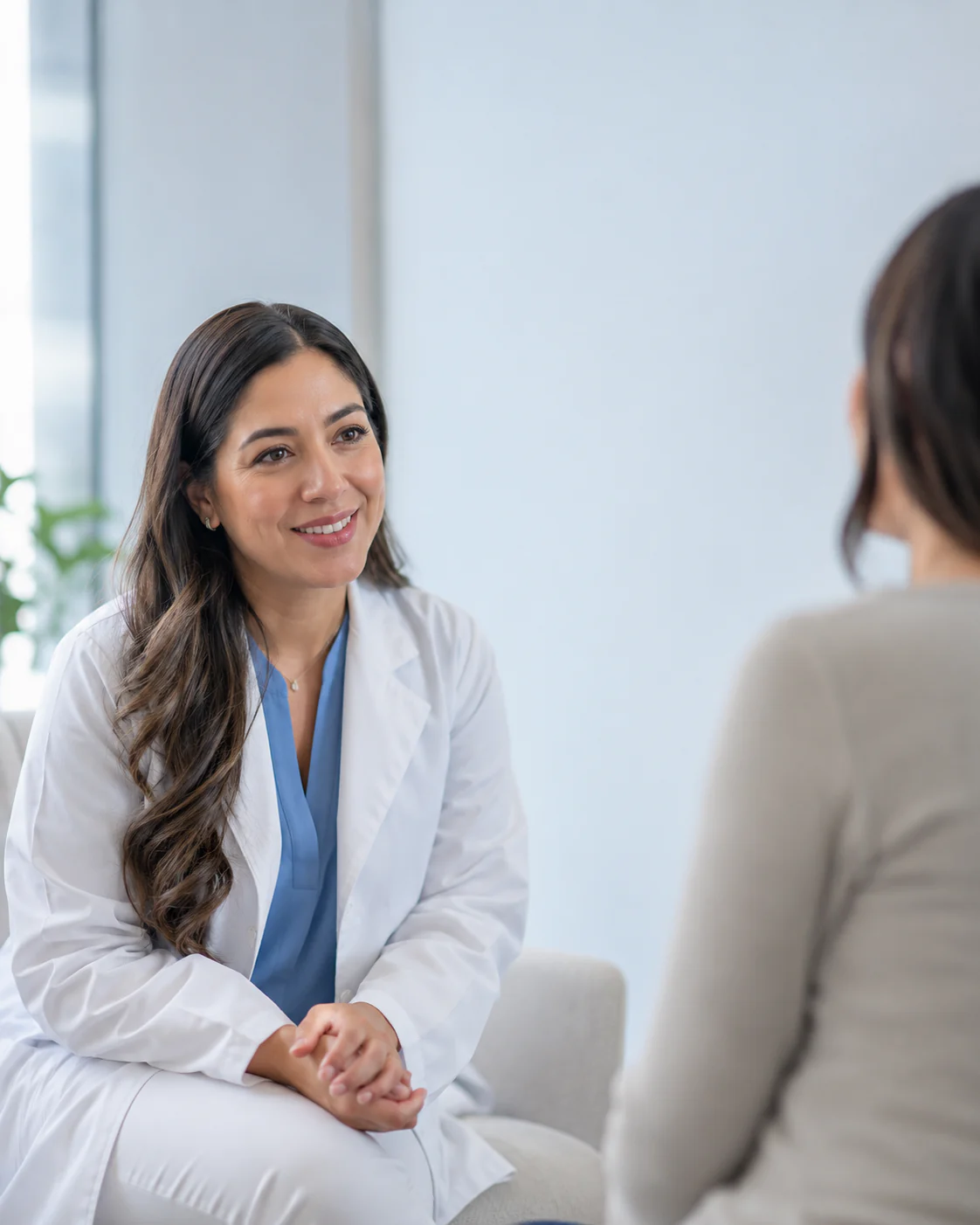 Médica durante una consulta con una paciente en un consultorio.